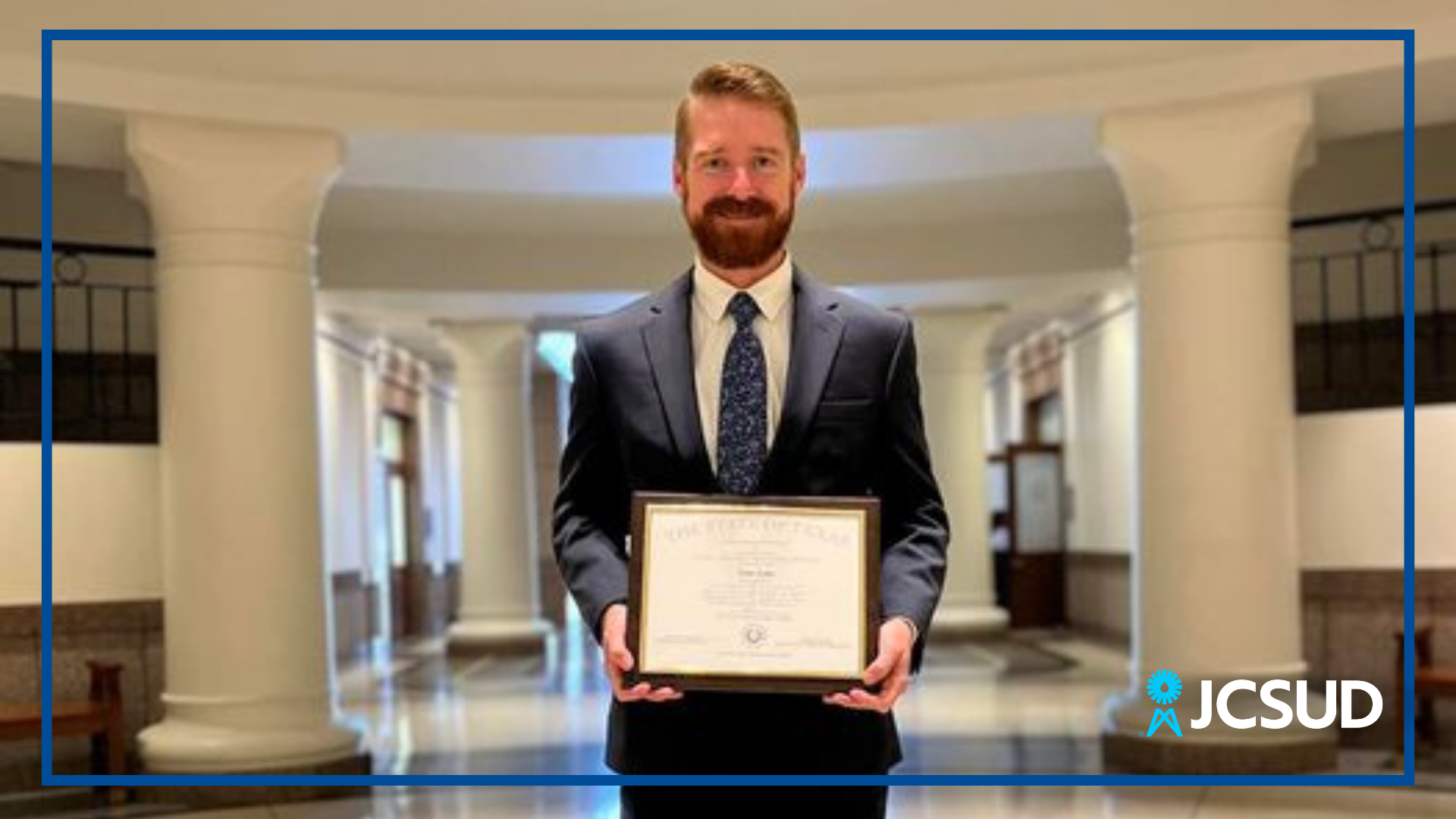Man holding a certificate in Texas capitol 