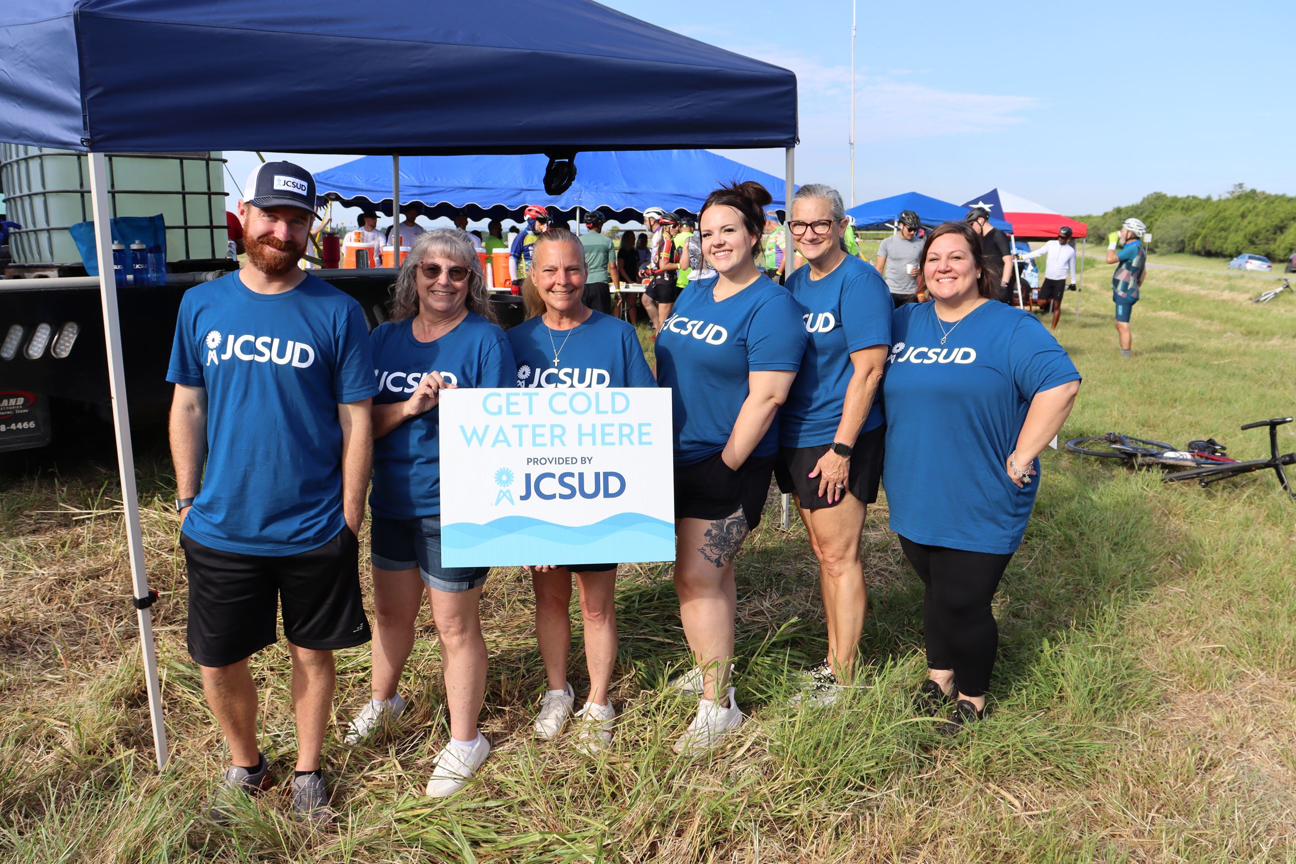 JCSUD staff volunteering to give out water to bike riders at an event